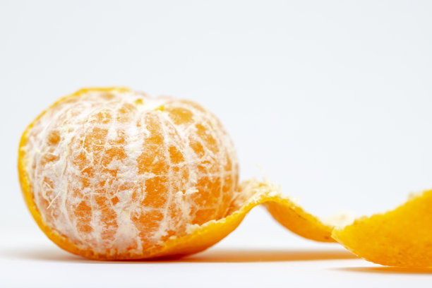 橘汁特写照片上的白色背景。亮橙色的柑橘类水果。整个橘子剥落。图片下载
