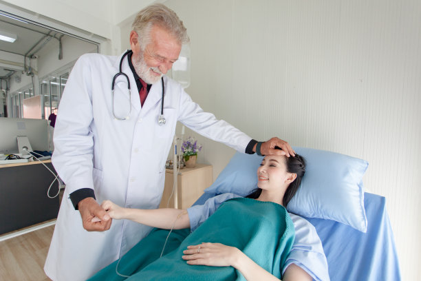 医生正在检查这个人的症状。医生摸了摸病人的前额图片下载