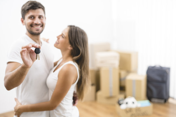 这对夫妇拿着纸箱背景上的钥匙图片下载