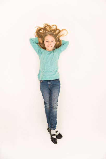 那个快乐的女孩躺在地板上。从上面的观点图片下载