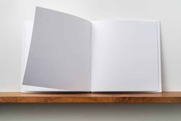 白色的方形笔记本放在书架和白色的墙壁上图片下载