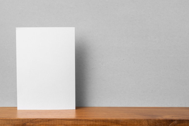书架和灰色墙壁上A4纸的正面视图图片下载