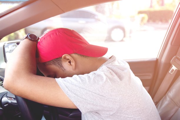 疲惫的年轻人在开车。睡在车里，筋疲力尽。图片下载