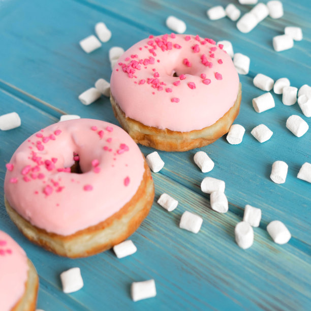 蓝色背景下粉色甜甜圈的照片。框架文本与甜甜圈和糖果。基础与甜甜圈横幅。社交网络，商店，咖啡馆的甜甜圈横幅图片下载