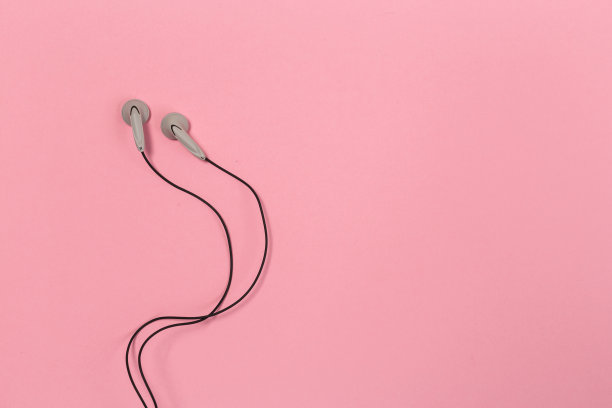 彩色背景上的耳机。粉色背景的白色耳机。前视图。平的。副本的空间。时尚的彩色照片。以彩色纸为背景的简约风格。音乐的概念图片下载