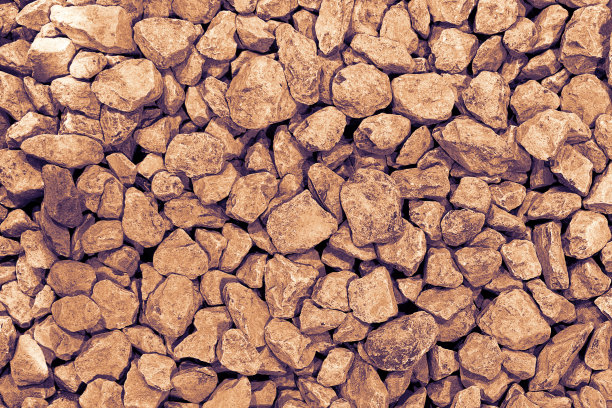 背景来自一个圆形的浅棕色的石头。黑色的鹅卵石近距离折叠。长方形的照片。图片下载