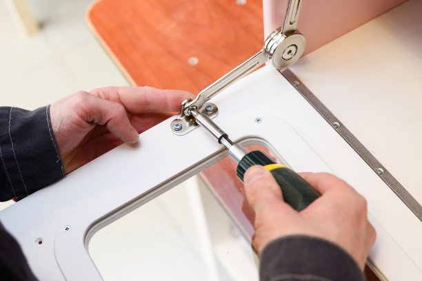 做玩具家具的木匠。在游戏厨房烤箱门上安装关闭器图片下载