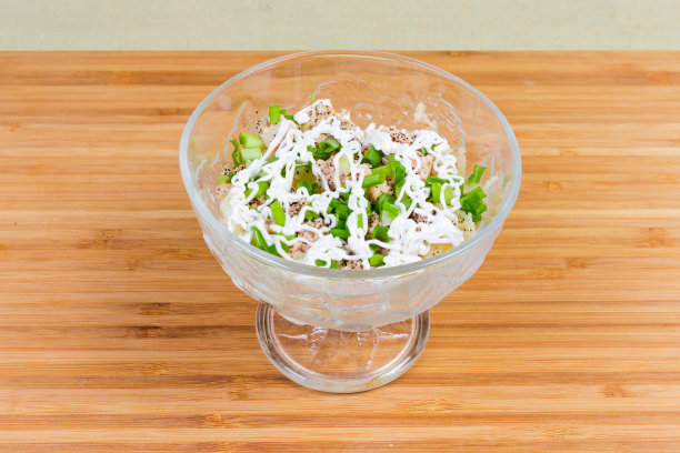 玻璃碗里的鳕鱼肝和煮蔬菜沙拉图片下载