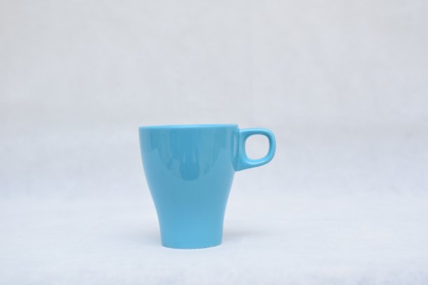 白色背景上的蓝色陶瓷热饮杯图片下载
