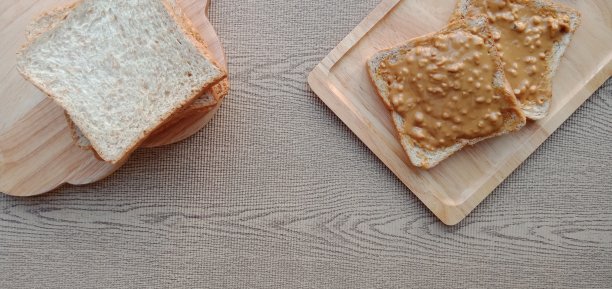 一堆全麦面包和一些花生酱在上面。图片下载