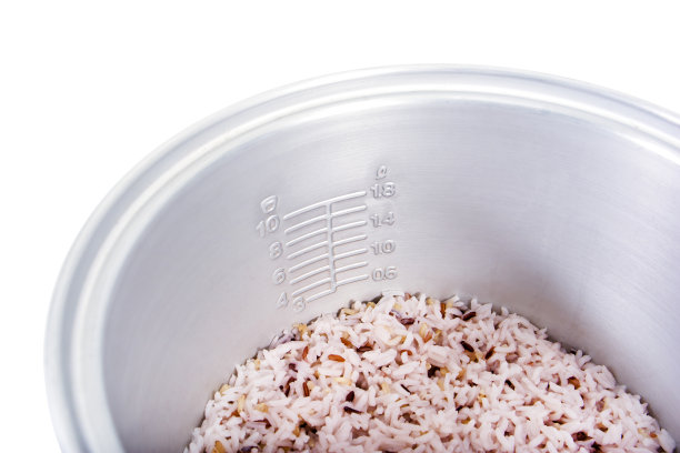 电饭锅内部，米饭和鳞片被孤立在白色的背景上图片下载