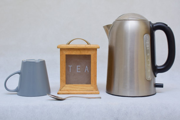 彩色陶瓷马克杯、木制茶叶盒和不锈钢热水壶图片下载