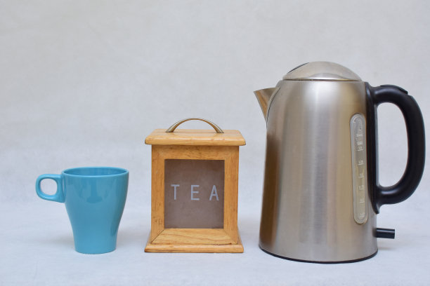 彩色陶瓷马克杯、木制茶叶盒和不锈钢热水壶图片下载