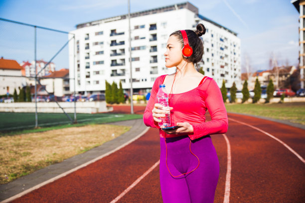 年轻的女运动员在户外休息图片下载
