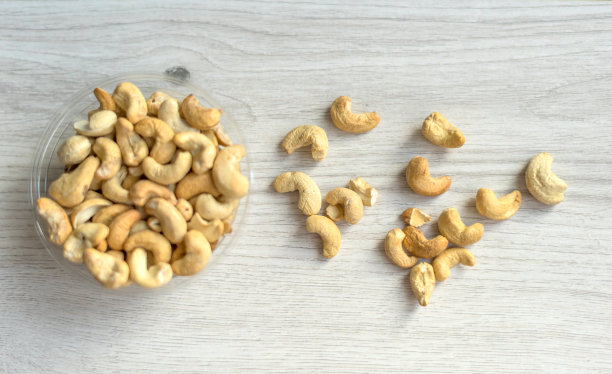 健康的食物背景图片特写腰果。坚果纹理在白色灰色的桌子上的杯子盘上的视图图片下载