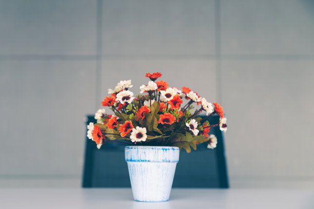 一个彩色的花瓶花瓶在桌子上的椅子和墙壁背景与柔和的颜色。图片下载