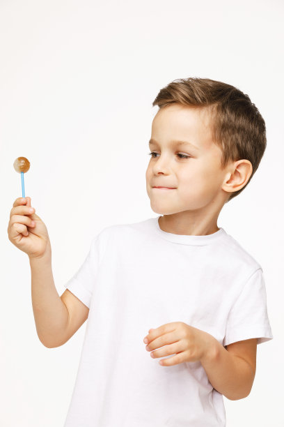 白色背景上拿着棒棒糖的小男孩图片下载