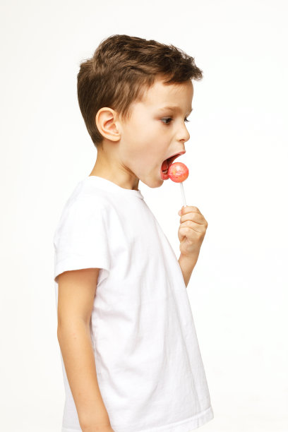 白色背景上拿着棒棒糖的小男孩图片下载