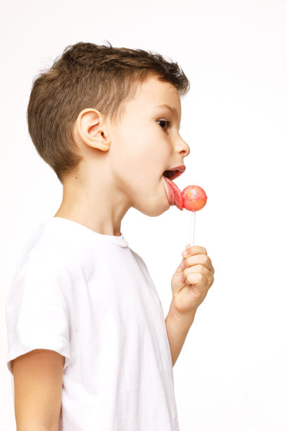 白色背景上拿着棒棒糖的小男孩图片下载
