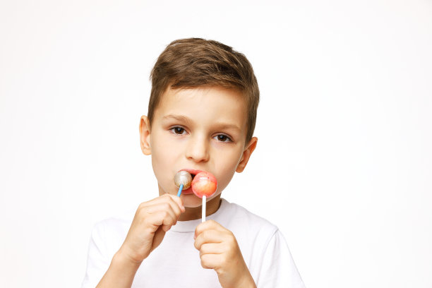 白色背景上拿着棒棒糖的小男孩图片下载