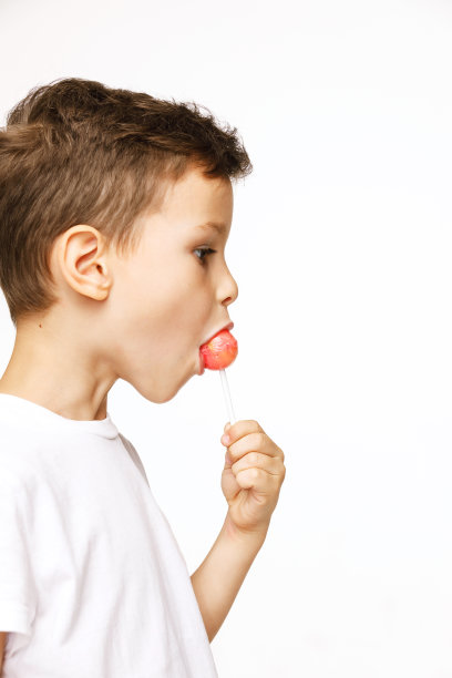 白色背景上拿着棒棒糖的小男孩图片下载