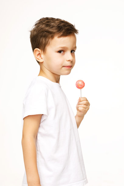 白色背景上拿着棒棒糖的小男孩图片下载