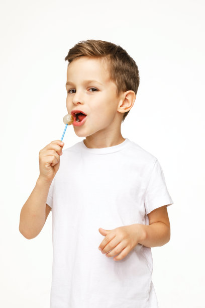 白色背景上拿着棒棒糖的小男孩图片下载