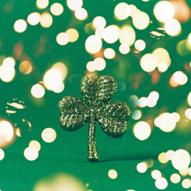 绿纸背景上闪着三叶草。圣帕特里克节的象征。爱尔兰国定假日概念。大胆的节日散景图片下载