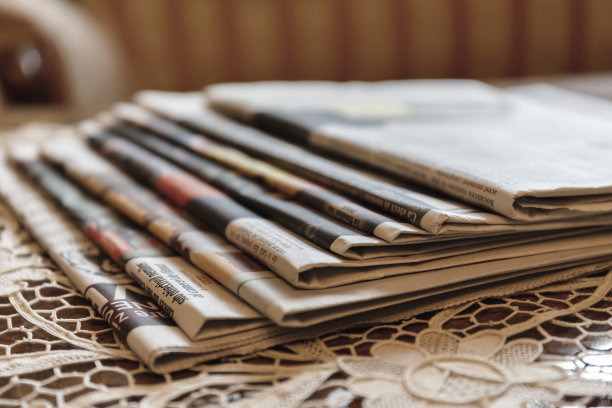 几份报纸放在复古的白色工作花边桌布上图片下载