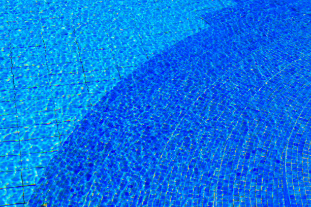 游泳池中的水的纹理作为背景。蓝色的游泳池表面图片下载
