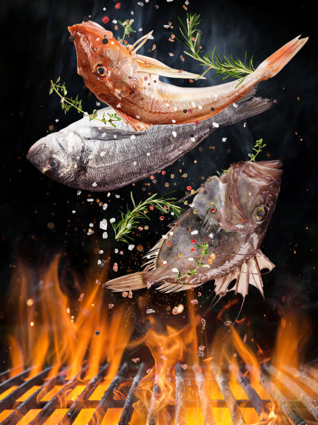 美味的鱼在火焰中飞舞在铸铁炉排上。图片下载