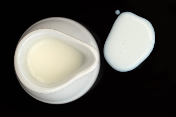 从上面看黑色背景上的小牛奶罐图片下载