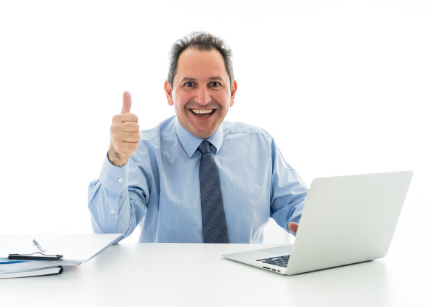 微笑自信的中年行政商人在笔记本电脑上工作，竖起大拇指，表示工作愉快。在商业上，积极的环境和技术。孤立在白色的。图片下载