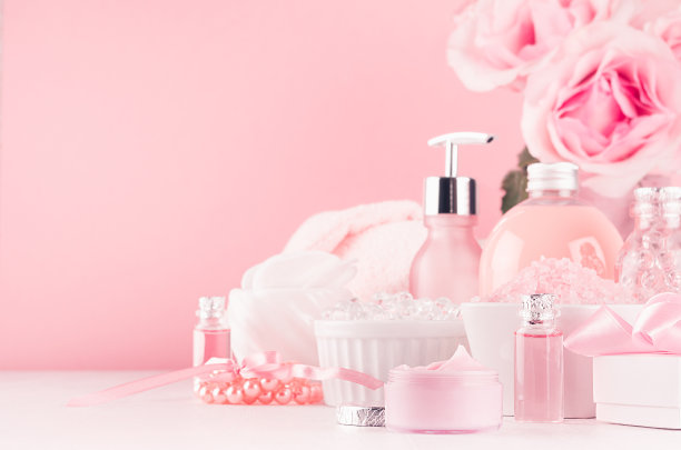 现代温柔的女孩浴室装饰-化妆品的沭浴和水疗中心，玫瑰花束，沭浴配件，珠宝在柔软的白色木制桌子，粉彩墙，特写。图片下载