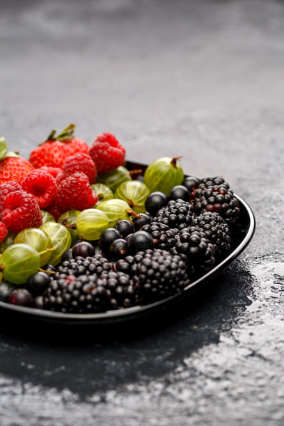 黑莓，草莓，覆盆子，醋栗的照片在黑色的盘子图片下载