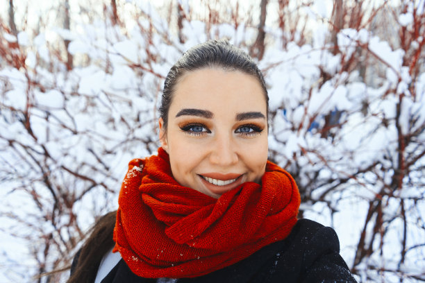 年轻漂亮的女人在冬季公园或森林里自拍。图片下载