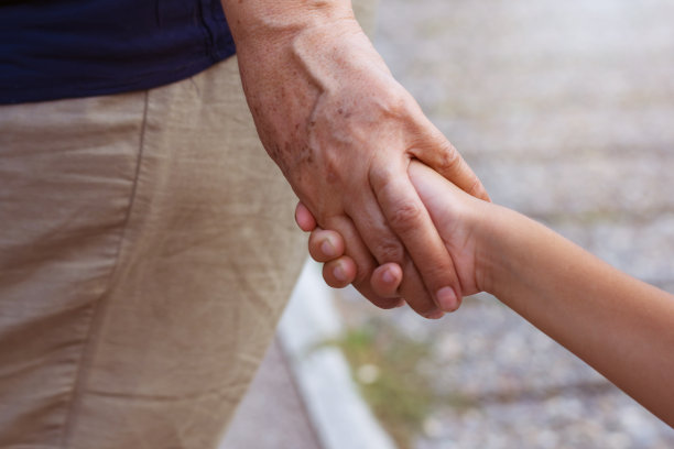 奶奶拉着小孙子的手走在街上。家庭的概念。有选择性的重点图片下载