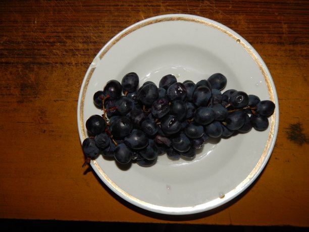 盘子上放着黑色的葡萄图片下载