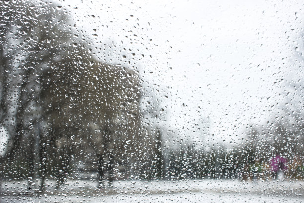 城市公园景观前的玻璃上的散景滴纹理图片下载