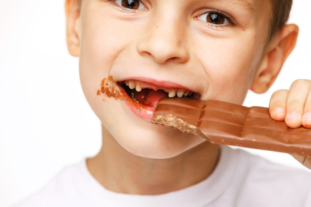 小美男吃着巧克力在工作室拍摄图片下载