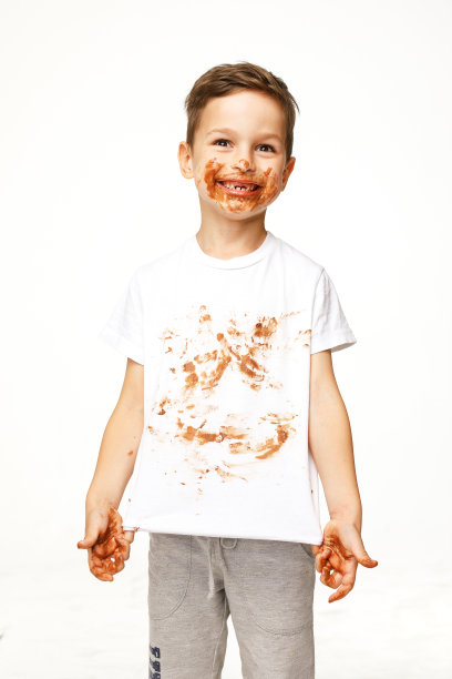 小男孩的脸和手都在巧克力里图片下载