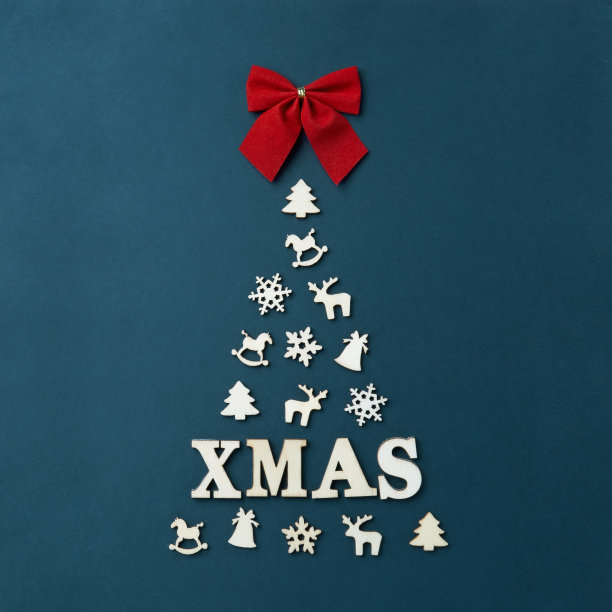 圣诞贺卡与短信圣诞。一棵巨大的圣诞树在黑暗的背景下，排列着白色的雪花形状的木制人物，一棵圣诞树，一匹马，一只鹿，一个钟。红色的蝴蝶结图片下载