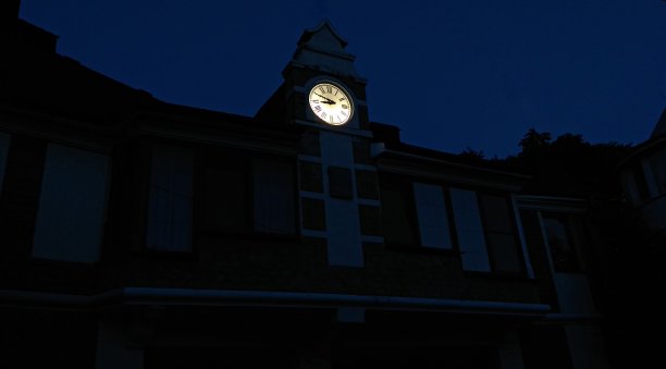 钟楼墙上的钟面是罗马数字，分针在10上，时针在9上。图片下载