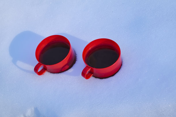雪地里放着两杯红色的热茶图片下载
