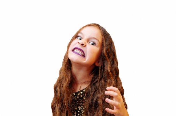 小女孩留着长发，穿着迷人的裙子，穿着高跟鞋，站在那里，情绪上摆出孤立的姿势图片下载