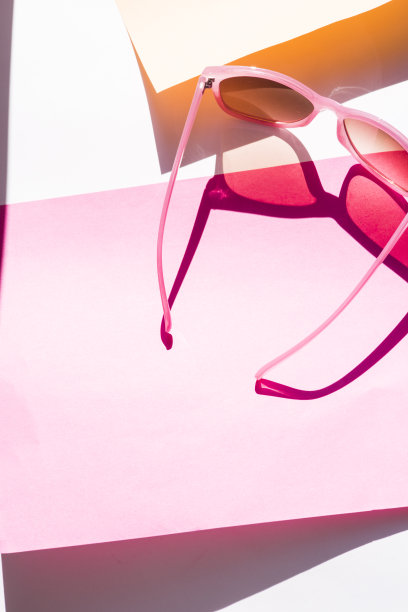 粉红色太阳镜，粉红色和黄色的背景和阴影。图片下载