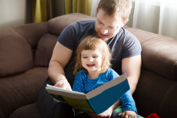 父亲给女儿读故事。家庭团聚的快乐时光。图片下载