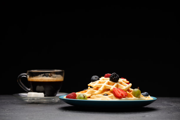 这是一杯咖啡和比利时的草莓和覆盆子薄饼的照片图片下载