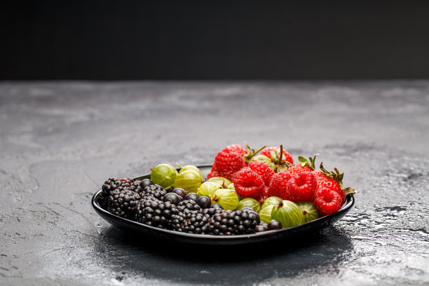 黑莓，草莓，覆盆子，醋栗的照片在黑色的盘子图片下载