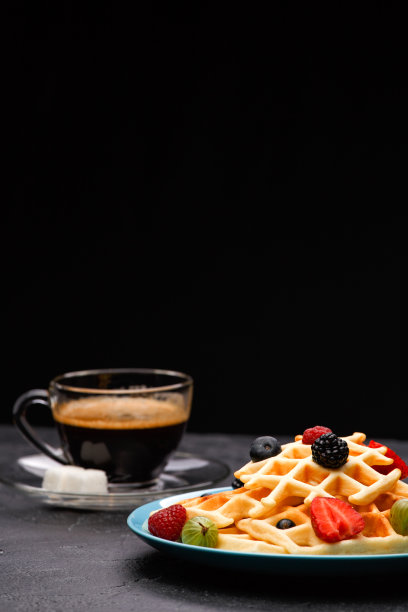 这是一杯咖啡和比利时的草莓和覆盆子薄饼的照片图片下载